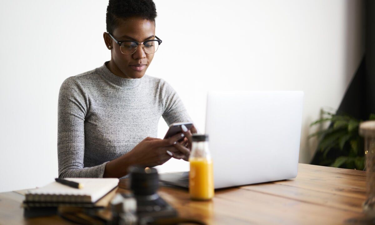 A customer checks her phone for a real estate SMS marketing message from a realtor.
