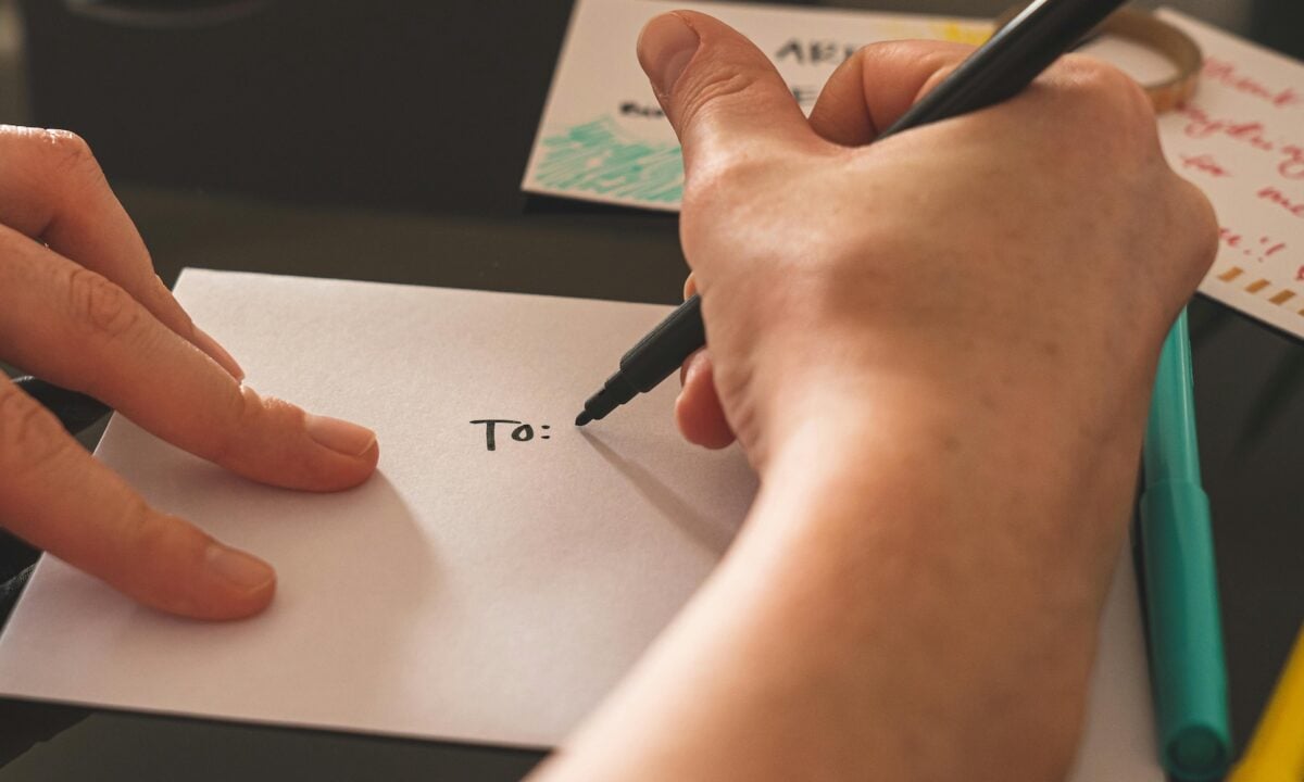 Real estate agent addressing an envelope to a prospect illustrating the need for personalization in marketing automation
