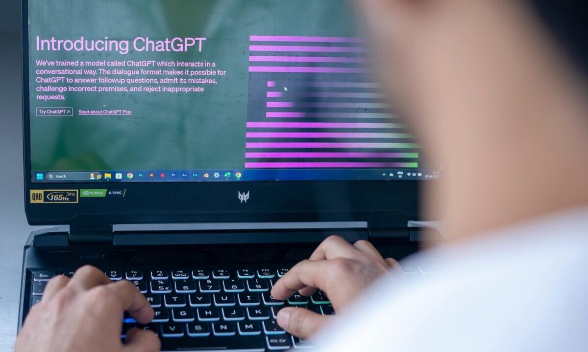 real estate agent sitting in front of a laptop using chatgpt prompts for email marketing