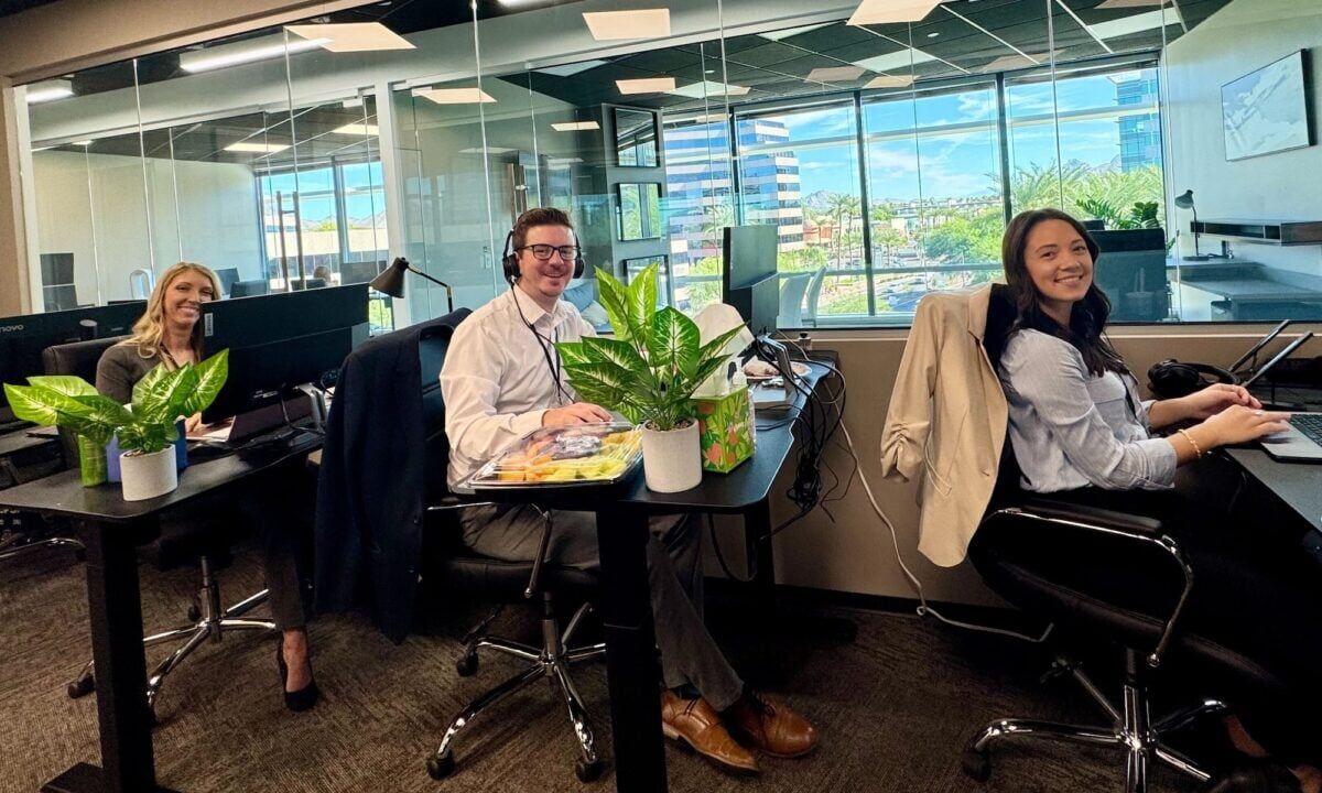 Three staff members in front of desktop computers with headsets on demonstrate the dedication behind the hundreds of Luxury Presence reviews on Google and other platforms